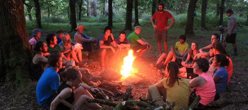 Dr. Kip Redick with a group of students around a campfire