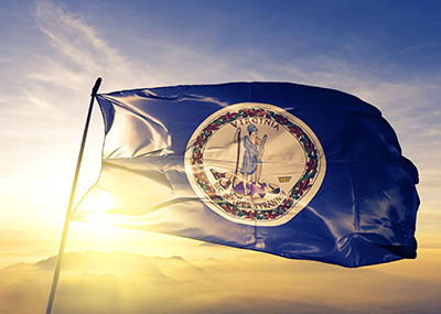 Virginia state flag against the sky at sunset