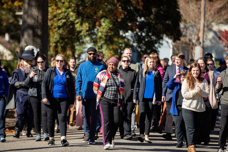 People of various ages, races, and ethnicities walk together during one of CNU's community walks.