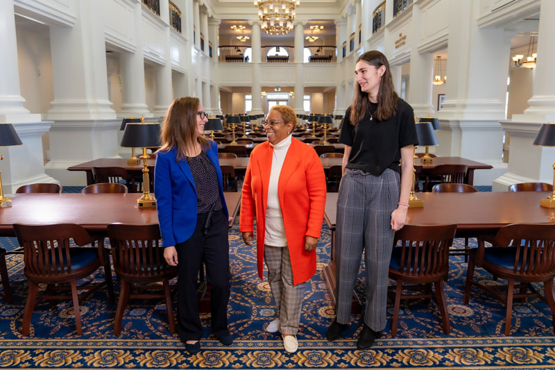 Laura Puaca, Susann Davis and Oliva Brubaker stand in the Rosemary Reading Room of the Trible Library