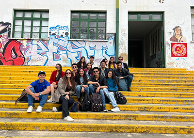 A group of students in Colombia sitting on yellow steps.