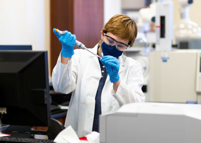 Student in a lab using a pipette