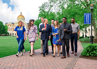 A group of students walking with President Paul Trible