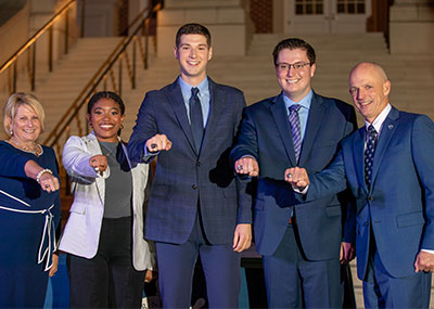 Students with the president and first lady holding up their new class rings