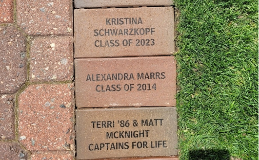 Inscribed bricks beside a patch of the Great Lawn