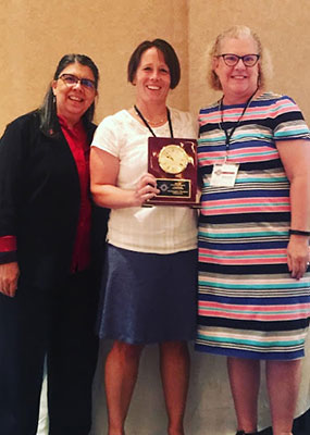 Dr. Lynn Shollen (center) accepts the Outstanding Program Award from the Association of Leadership Educators’ Barbara Altman (left) and Gina Matkin.