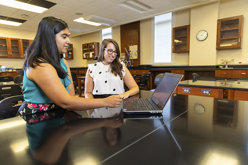 Psych Professor Dr. Leslie Rollins (right) works with a student (file photo)