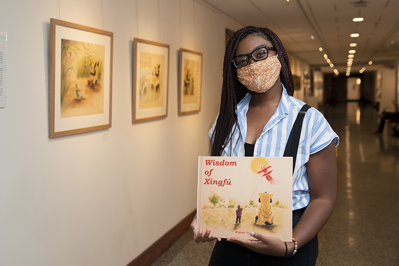 Whitney Truitt in the Ferguson Hall Gallery with her book, Wisdom of Xingfu