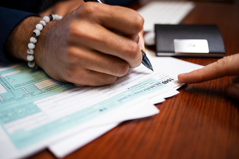 A person filling out a 1040 tax form.
