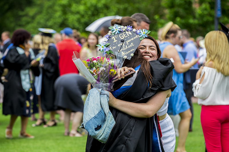 Graduates embrace on the Great Lawn