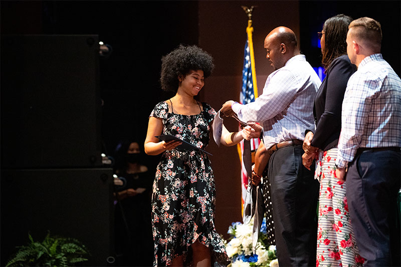 A Community Captain receives her stole and certificate of completion.