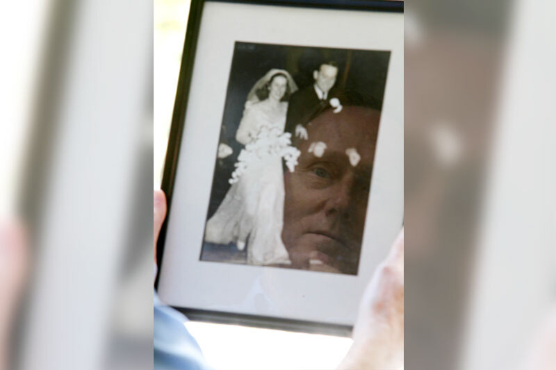 Photo of Willy Donaldson reflected in a framed photo of his parents