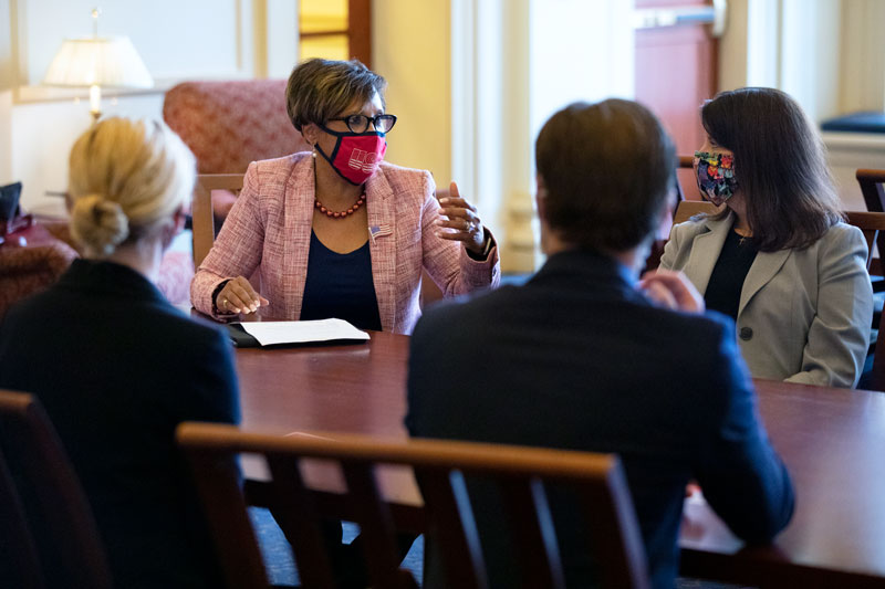 Sophia Nelson seated at a table talking with Dean Lori Underwood and two students