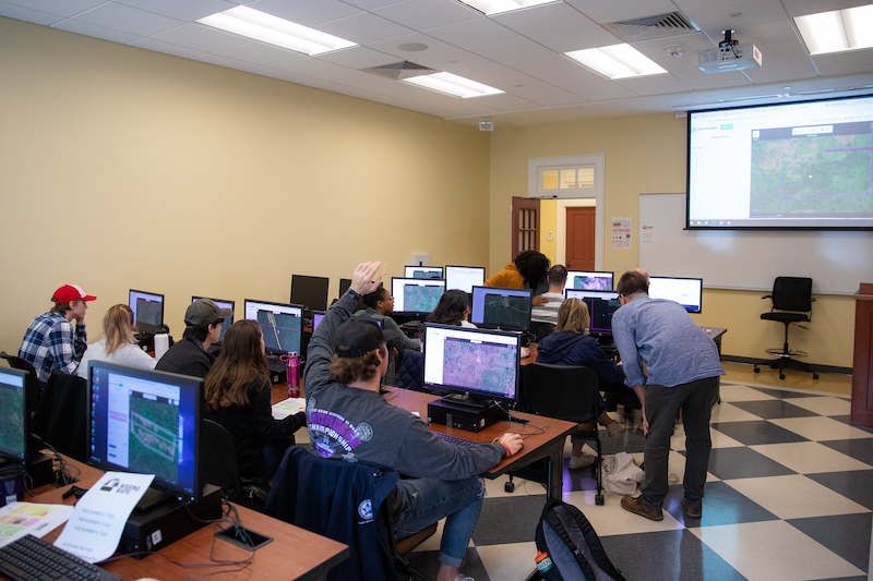 Students work on maps at computer workstations during the 2019 Mapathon