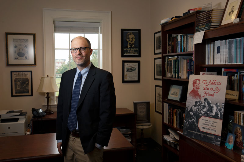 Portrait of Jon White standing in his office