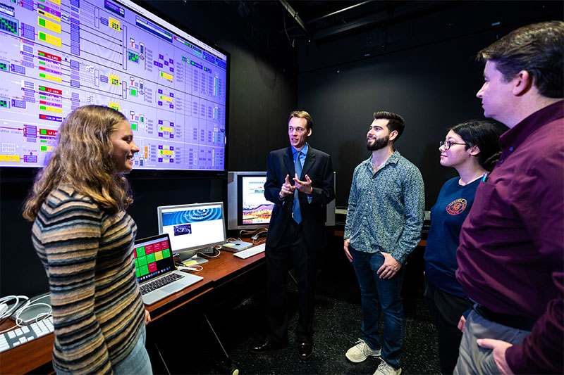 Dr. Ryan Fisher (center) speaks with students in the Advanced Laser Interferometer Gravitational-wave Observatory at CNU