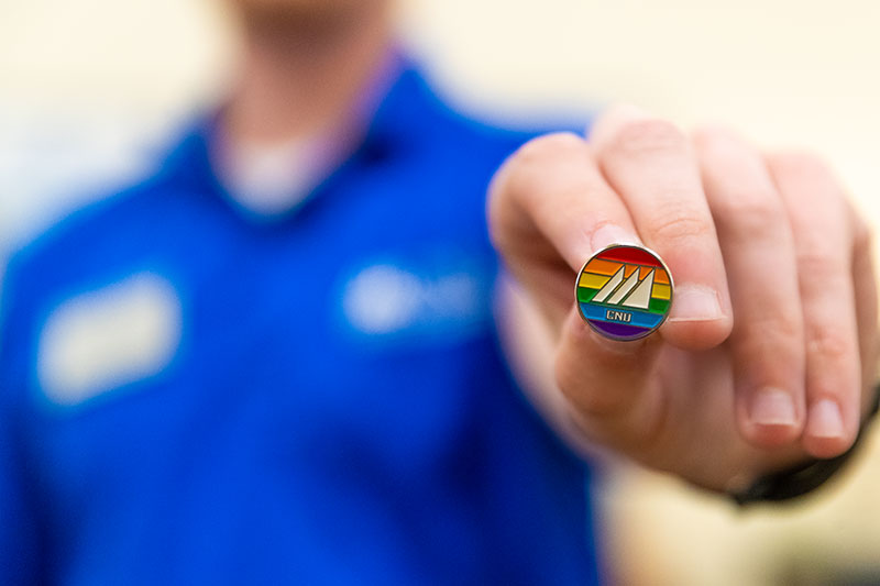 Staff member holding LGTBQ affinity group lapel pin