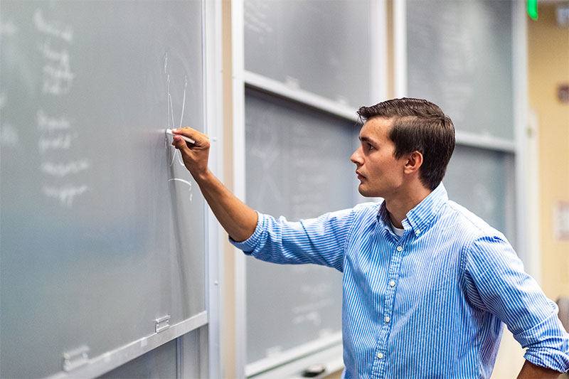 Michael Sparks working on a math problem on a chalkboard