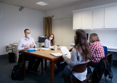 Photo of writing center consultants sitting at a table with clients