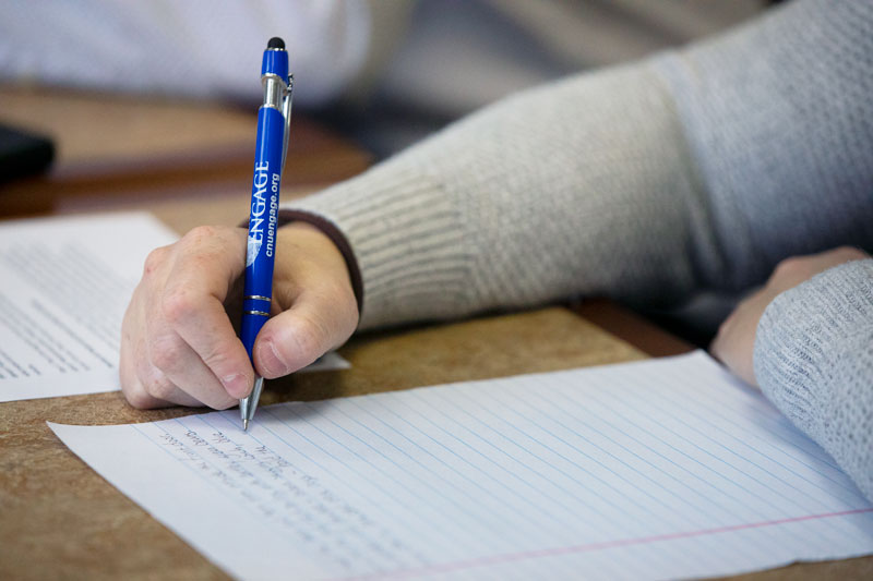 Photo of a writing center consultant taking notes