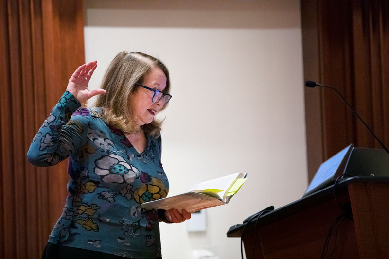 Photo of Barbara Kellerman reading from a book while speaking to the audience