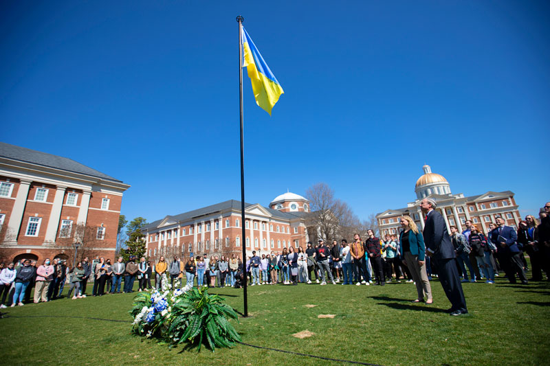 Photo of students, faculty and staff looking at the flag of Ukraine on the Great Lawn at Christopher Newport University