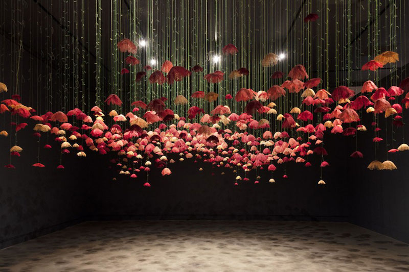 Amanda McCavour's Poppies - fiber poppies hanging from the ceiling of an art museum