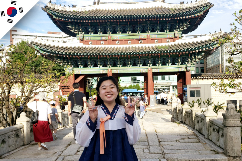 Abigail stands in front of Changgyeonggung palace while wearing a hanbok (traditional Korean wear). 