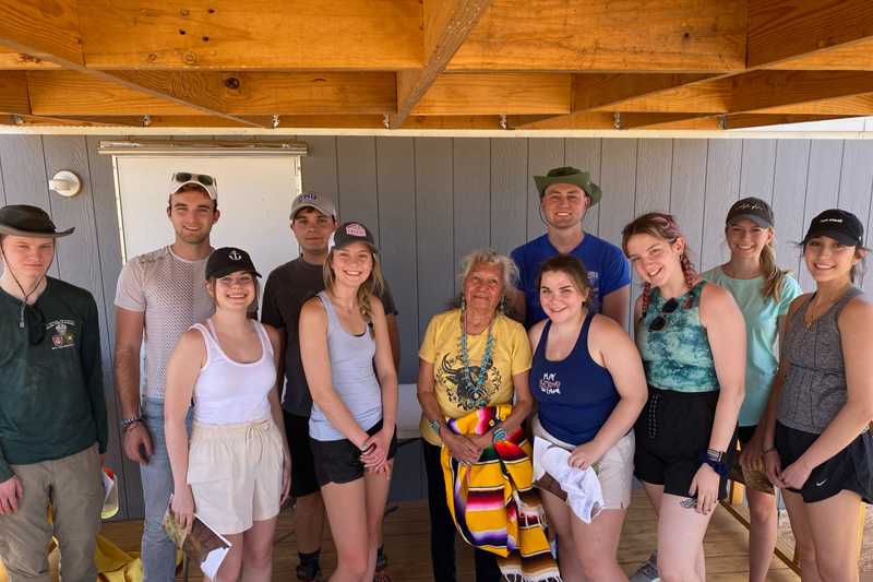 A group of CNU students stand with an elder of the Navajo Nation.