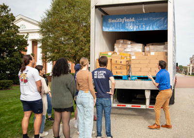 Students look on at the Smithfield foods truck while a member of Smithfield Foods  points out that it's full of protein.