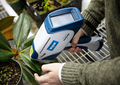 Patrick Wright using an x-ray fluorescence spectrometer on a plant sample