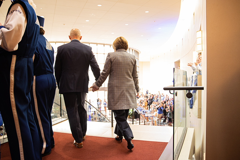 The backs of President Select William and Mrs. Angie Kelly as they walk down the stairs at the announcement of William becoming the next president of Christopher Newport University.