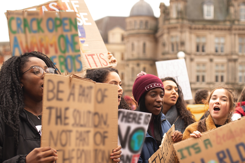 A group of individuals hold signs in protest.