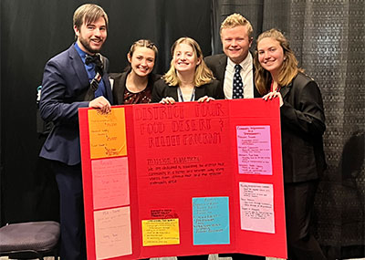 A group of five students holding their poster board during the Leadership Challenge event in Kansas.