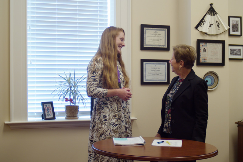 A student-teacher talks with their professor in an office.