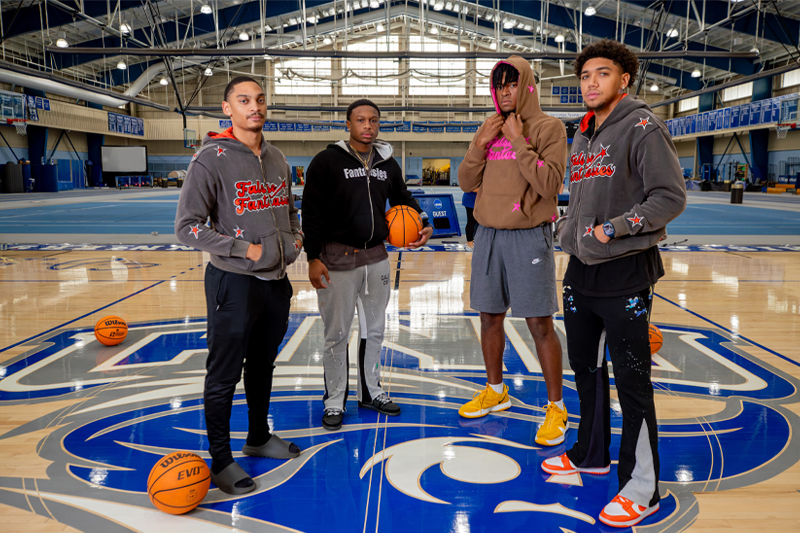 Members of CNU's men's basketball team wear False Fantasies hoodies in the Freeman Center Field House.