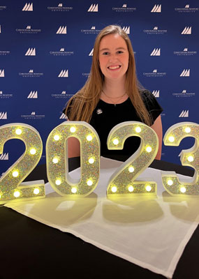 Sarah Flinn in front of illuminated 2023 number.