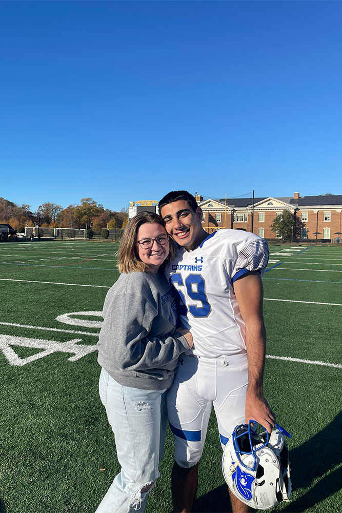 Caitlyn and Zack on a football field. Zack is in a Captains football uniform.