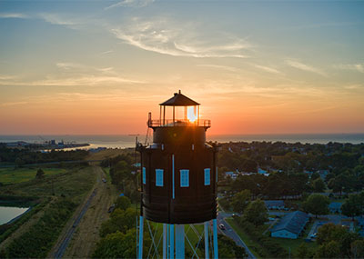 A water tower in the foreground as the sun sets over Cape Charles, Virginia