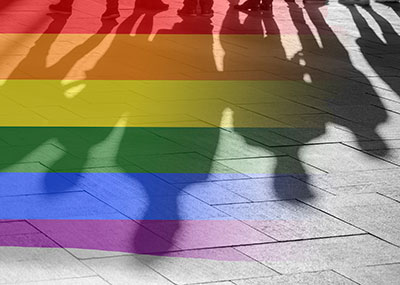 Pride rainbow flag overlaid on a photograph of people's shadows