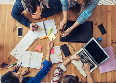 A group of people around a table with marketing materials