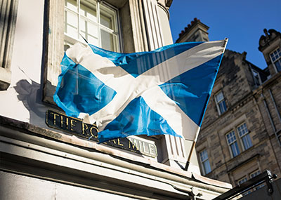 Scottish flag flying in front of a building on the Royal Mile