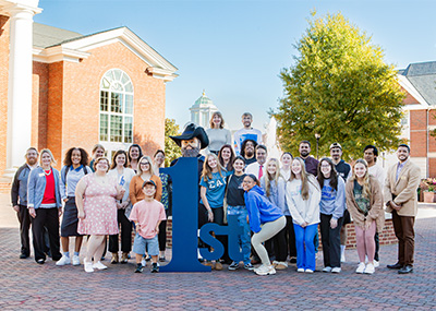 group photo of first generation students with Captain Chris in front of the fountain