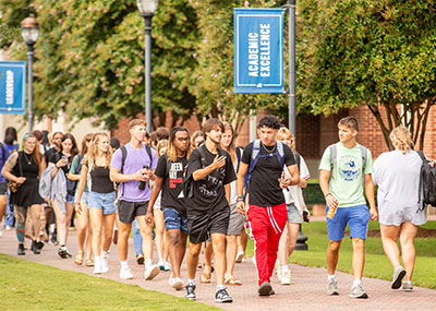 Students walk on campus in a large group