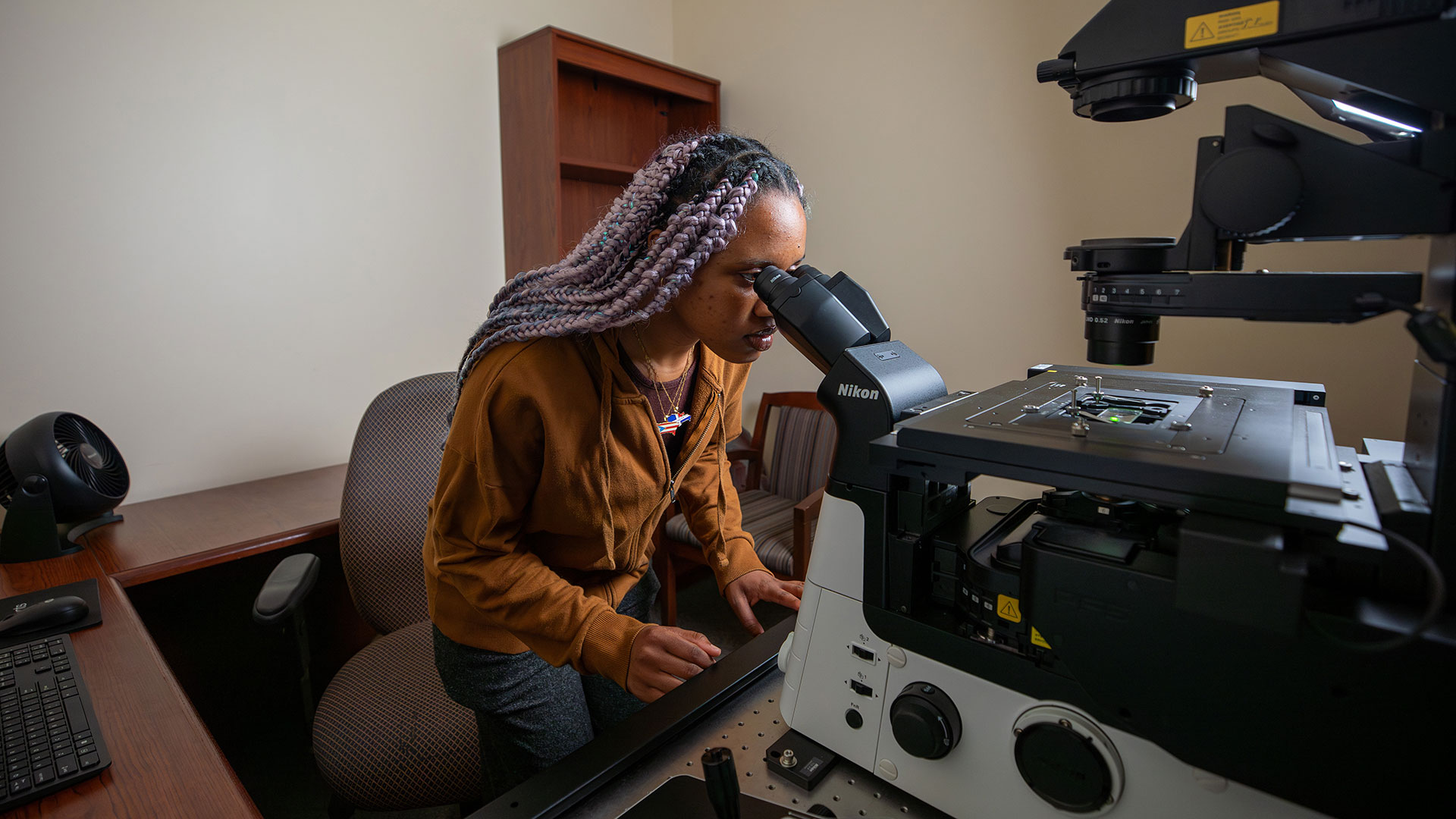 Student looking through microscope