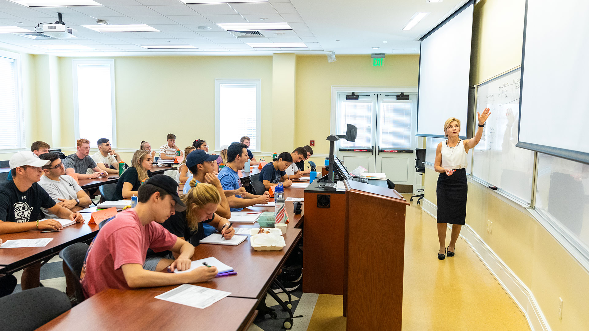 Students in a classroom in Luter listening to a professor as she points to something on a board