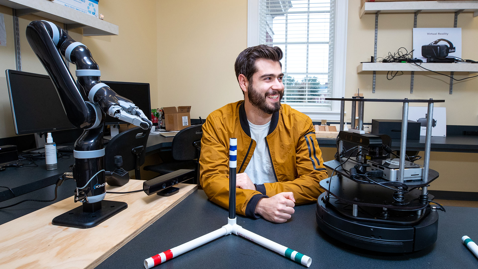 Student with a robotics arm in the lab