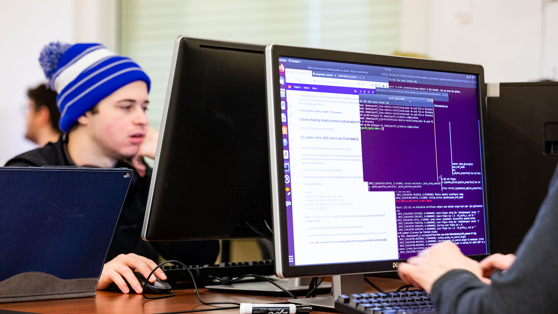 Students working at a computer with code on the screen