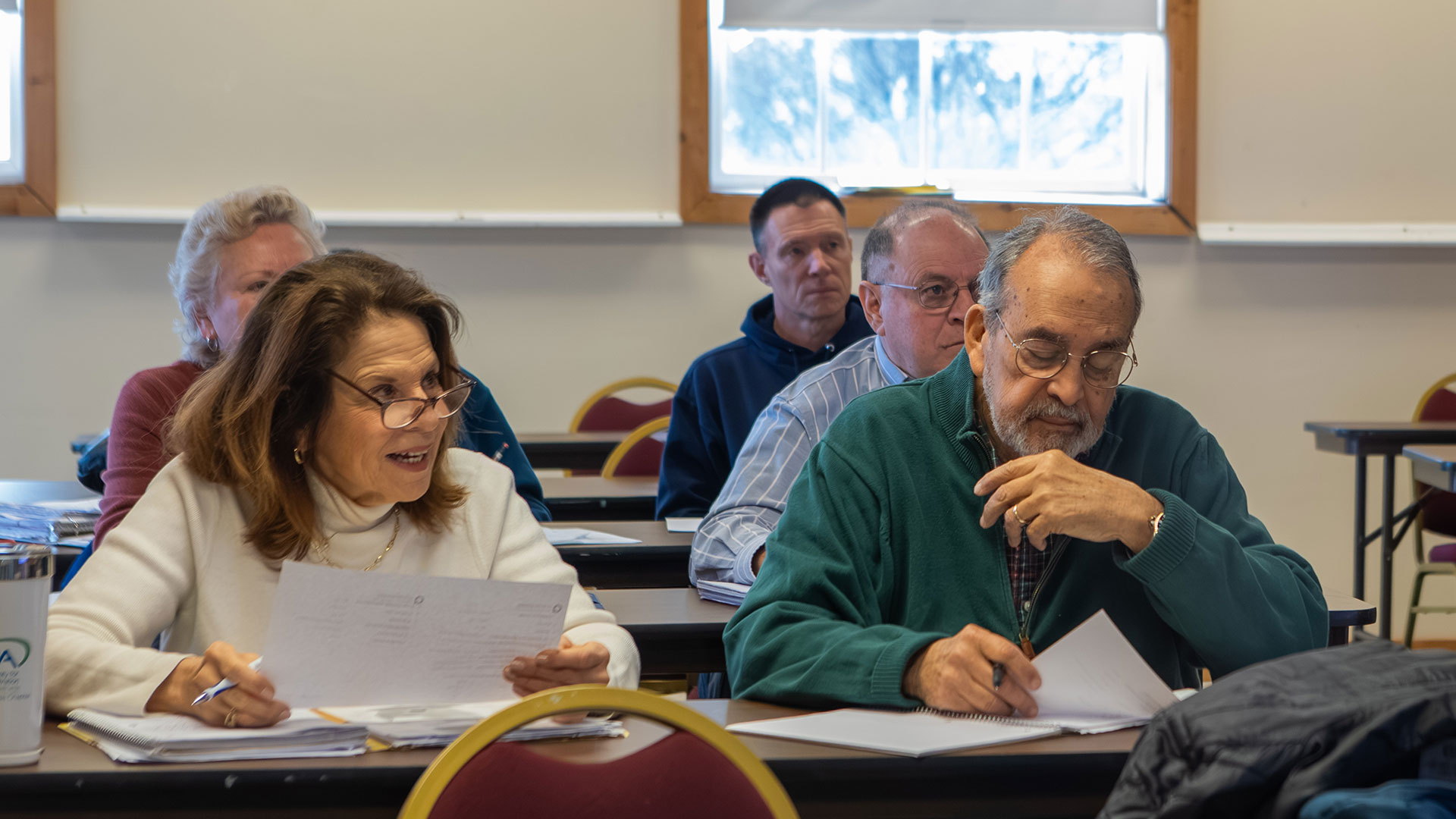 Lifelong Learning Society members sit at desks while in a classroom
