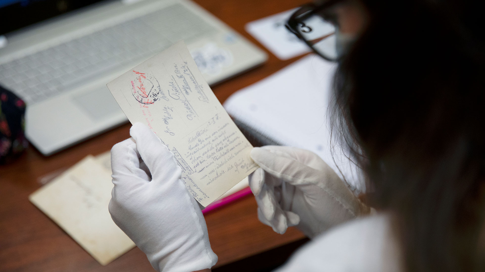 Student holding an old postcard